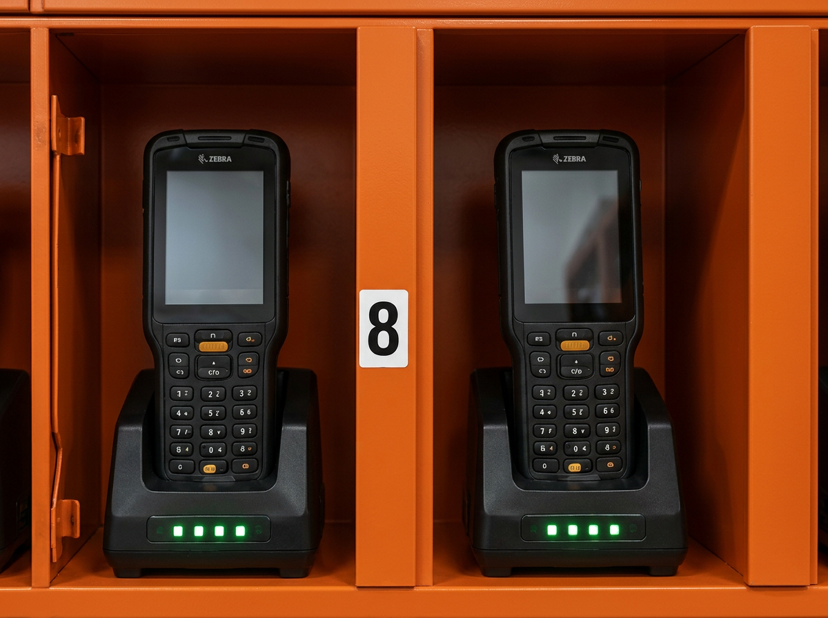 Zebra handheld scanner charging in a ShiftLoq locker bay with green LED indicators